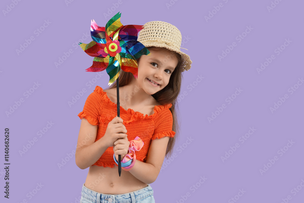 Little girl with toy windmill on lilac background