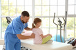 © Pixel-Shot - Physiotherapist working with little girl on couch in rehabilitation center