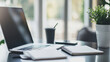 © Marcos Casado - A clean desk setup featuring a notebook, pen, and smartphone, with a small plant in the background, bright natural light, uncluttered and professional