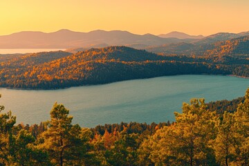 Fototapete - Serene landscape at sunset with mountains and a lake, showcasing nature's beauty.