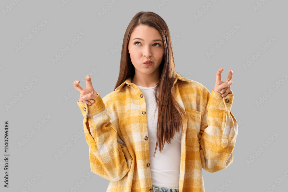 Beautiful thoughtful young woman showing quotes on grey background