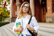 © maxbelchenko - Student woman  outdoors with bag and books near University. Education, campus, friendship and people concept