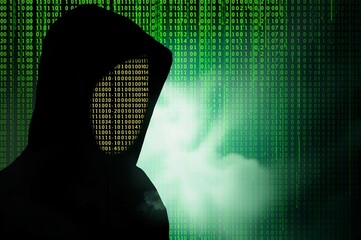 mysterious hacker silhouette against binary code background