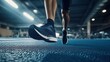 © lucegrafiar - Close-up of a runners legs and shoes pushes through a workout on the blue gym floor.