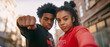 © MonkaLemonka - couple of african american or latin teen girl & boy making fist gesture; 2 teenagers are standing outside, wearing hoodies