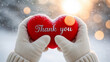 © tanya78 - hands in warm gloves holding a red heart with the inscription thank you, sunny snowy day
