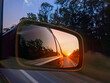 © Yavolha - The sun is reflected in the mirror of a car driving on the highway. Evening trip.