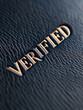 © SashaMagic - Word 'Verified' embossed on leather surface.