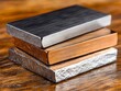 © VISUAL BACKGROUND - A stack of three different colored metal blocks on a wooden table