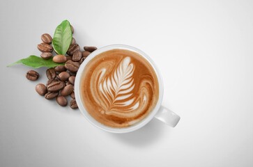 Wall Mural - Cup of tasty hot coffee and coffee beans on desk