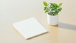 © Parsudi - A minimalistic workspace with a notebook and a potted plant.