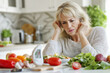 © Юля Бурмистрова - Middle-aged woman contemplating her meal choices at a bright kitchen table. Generative AI