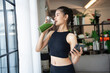 © Charlie's - Fitness asian woman using smart phone and drinking organic green smoothie fruit detox for diet after workout exercise.training healthy lifestyle