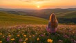 © LesaMurina Coll - A serene sunset view over rolling hills with a person sitting in a flower-filled meadow.