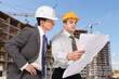 © BillionPhotos.com - Two Architect worker discussing building plan at construction site
