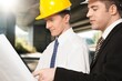 © BillionPhotos.com - Two Architect worker discussing building plan at construction site