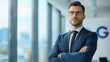 © Vilaysack - A confident businessman in a suit stands in an office with large windows, exuding professionalism and determination.