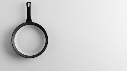 Black frying pan with plastic handle resting on a clean white background for kitchenware and cooking concepts in advertising and design.