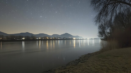 Wall Mural - Night landscape of a calm river reflecting city lights and stars.