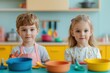 © artchvit - Primary play is colorful and imaginative. Two kids playing with colorful bowls in a bright kitchen.