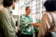 © Maskot - Smiling female entrepreneur doing handshake with female delegate at convention center
