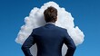 © NAPHAT - Cloud Computing Concept: A businessman stands with his back to the viewer, facing a large stylized cloud against a clear blue sky, symbolizing the vast potential and possibilities of cloud computing.