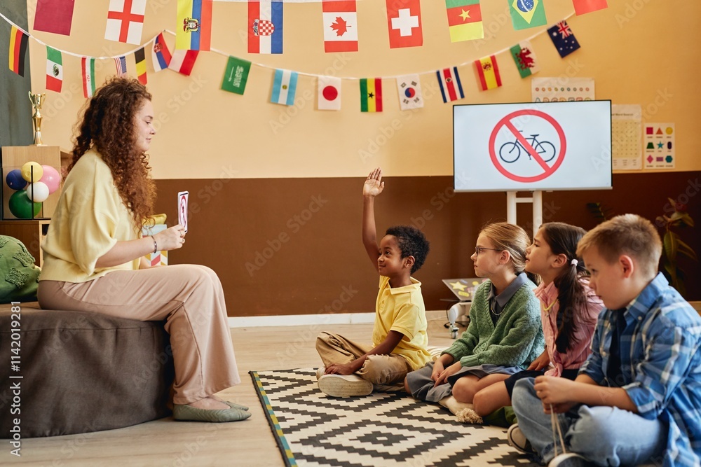 Side view of young African American boy raising hand while sitting on ...