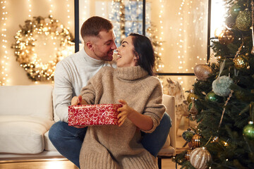 Gift for a woman. Couple is celebrating new year indoors together