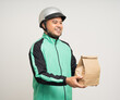 © Chanakon - Young asian rider wearing green jacket uniform and helmet various action holding food paper bag delivery to customer. Male delivery service worker. Courier and shipping food service.