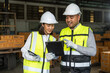 © Chanakon - Professional engineer and technician wearing safety helmet analyzing meeting with tablet in factory warehouse. Confident factory workers group inspection industry factory. Teamwork concept.