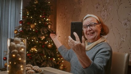 Senior woman celebrating Christmas on a conference call with her children. 