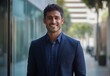 © ANUAR - Confident Young Man in Smart Casual Attire Standing Outdoors with Urban Background Smiling at Camera in Bright Natural Light