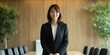 © Christopher - A Japanese female project manager standing confidently in a boardroom, presenting a proposal