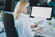 © deagreez - Photo of data analytic blonde lady working with information holding diagrams wearing formal white shirt and eyeglasses at office