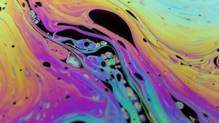 Wall Mural - Closeup video of a soap bubble showing thin film interference concept and the resulting different colors of light with each moving and swirling shapes. Perfect for illustrating concepts of physics.