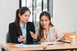 © kenchiro168 - Two businesswomen discussing work at desk with documents