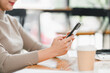 © kenchiro168 - woman using smartphone at wooden table with coffee cup