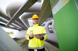 © FotoArtist - Worker Conducts Inspection of Pipeline Infrastructure Wearing Safety Gear in Industrial Area