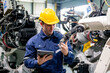 © FotoArtist - Aerial view of a technician assessing robotic machinery in a modern manufacturing facility