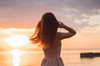 © Vella - Girl at sunrise on the sea. Silhouette of a slender young girl against the backdrop of the rising sun. Summer, sea, rocks. Vacation at sea. Vacation in warm regions.