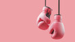 © robert - Pair of hanging pink boxing gloves representing concept of women fighting cancer and female health issues