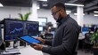© 69 - Professional Man Analyzing Data on Tablet in Modern Office Setting