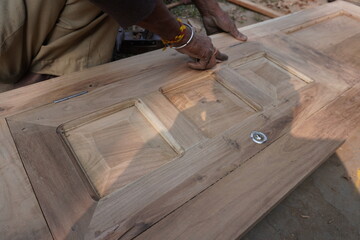 Wall Mural - Carpenter is polishing on the wooden door