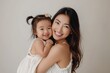 © Vlad - Toddler Asian. Beautiful Asian Girl Smiling with Happy Mother on White Background