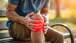 © Maryna - Man sits outdoors holding painful knee. Red highlight emphasizes knee injury. Possible scenarios for photo include health awareness campaigns for sports injuries, injury prevention in active