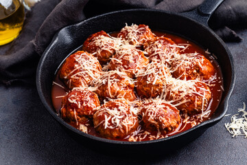 Wall Mural - Beef meatballs with tomato sauce and parmesan cheese on gray background, close up