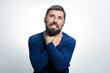 © Niko_Dali - A bearded man with a pained expression clutches his throat with both hands against a light background. He appears to be choking or experiencing discomfort.