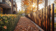 © Sawyer0 - Ścieżka pokryta jesiennymi liśćmi prowadzi wzdłuż drewnianego płotu. Wokół rosną drzewa i krzewy oświetlone delikatnym blaskiem zachodzącego słońca.