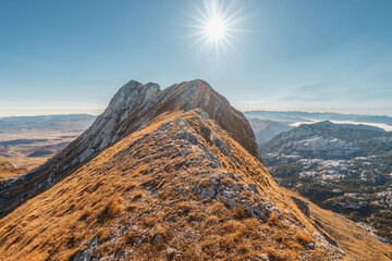 Wall Mural - Golden light bathes a rugged mountain ridge, showcasing nature's breathtaking beauty