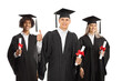 © Ljupco Smokovski - College graduate students  in graduation gowns holding diplomas and giving thumbs up